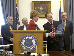 Gov. Jodi Rell enters the final keystrokes on a laptop held by UConn's Rob Vietzke to connect the Connecticut Education Network and the University of Connecticut to the Northeast Research and Education Network.