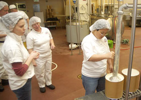 Sun Kim, a graduate student studying animal science, fills three-gallon containers with ice cream