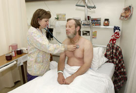 Pam Bouten, RN, 7th floor assistant nurse manager, listens to the heart of a patient.