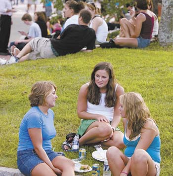 Kristin LeFebvre, left, Claire Vecchione, center, and Ashley Sleeba, all freshmen, chat during a campus picnic along Fairfield Way, one of the Husky WOW activities to welcome students.