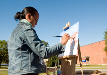 Tyanna Brooks, a senior majoring in illustration, paints outside the Fine Arts Building.
