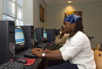 Ali Langston, a freshman, uses a computer at the Wilbur Cross Building. Behind him is Moravia Latortue, a freshman majoring in civil engineering.