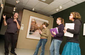 Barry Rosenberg, director of the Contemporary Art Galleries, discusses a work of art with student docents from E.O. Smith High School, from left, Amy Chalifoux, Katie Hannafin, and Rebecca Noonan. 