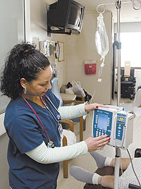 Angela Ferrer, a nurse at John Dempsey Hospital, adjusts the setting on a 'smart pump.'