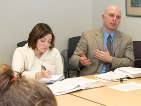 Gregory Semenza, right, assistant professor of English, teaches a graduate class in the CLAS Building