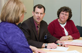 Dr. Thomas Van Hoof, center, speaks with Donna Bailey-Gates, left, and Vera Dynder in a conference room at the Health Center.