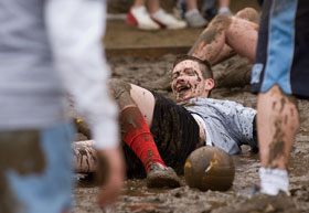 Matt Boland, a junior, slides through the mud while playing Oozeball. Teams competed on the lawn in front of the Wilbur Cross Building during Spring Weekend.