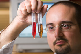 Richard Mancini, a new faculty member in animal science, holds vials of solution derived from meat, at his lab at the White Building.
