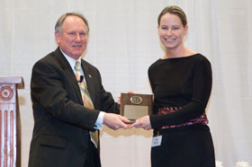 Keith Barker, director of the Institute for Teaching and Learning, hands an award to graduate student Linda Patrylak for her outstanding teaching.