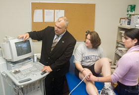 Kinesiology professsor William Kraemer and Ph.D. students Disa Hatfield, center, and Maren Fragala discuss an ultrasound. Kraemer specializes in exercise physiology, sports medicine, and strength and conditioning.