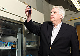 Robert Birge, professor of chemistry, examines a test tube containing rhodopsin, a protein he is studying that allows the human eye to see in low light.