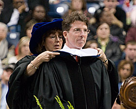 Sally Reis Renzulli, professor of educational psychology, hoods Robert Diamond Jr. as he receives an honorary degree during Commencement Dec. 17.