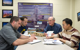 John DeWolf, a professor of civil and environmental engineering, discusses bridge monitoring research with (clockwise from left) Gino Troiano, a master’s student, and Josh Olund and Chengyin Liu, both doctoral students.