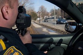 Officer Peter Zavickas of the UConn Police Department uses a laser gun to measure the speed of passing vehicles on North Eagleville Road.