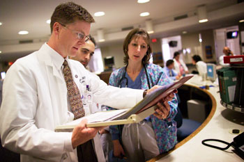 Dr. Kevin Dieckhaus, an assistant professor of infectious diseases, discusses a patient’s care with colleagues at the John Dempsey Hospital.