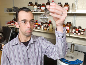 Nicholas Leadbeater, an assistant professor of chemistry, examines a sample in preparation for a microwave test.