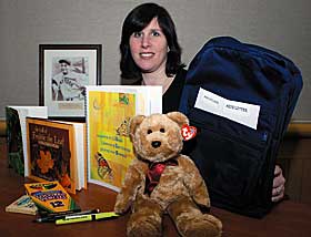 Deborah Feigenbaum, a clinical social worker at the Health Center, displays the items in the special backpack she created for youngsters who have a family member with ALS.