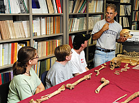 State Archaeologist Nicholas Bellantoni looks over artifacts with archaeology field school students.
