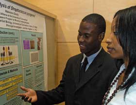 Makenson Delroy, a biomedical engineering major, discusses a research poster with his mentor, Marsenia Harrison, a Ph.D. candidate in molecular and cell biology.
