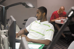 Former men’s basketball player Hilton Armstrong uses a computer in the study hall at Gampel Pavilion.