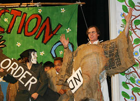 John Bell, right, wearing burlap, during a performance with members of the Bread and Puppet Theater in Cambridge, Mass.