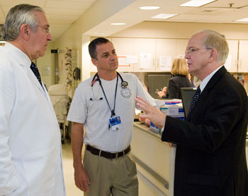 University President Michael J. Hogan, right, speaks with Dr. Peter Deckers, right, executive vice president for health affairs, and Dr. Robert Fuller, director of the Emergency Department, during a tour of the John Dempsey Hospital.