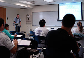 Ofer Harel, an assistant professor of statistics, teaches a class in a “tech ready” classroom in the CLAS Building. The panel on the front wall brings a variety of technologies into the room.