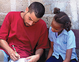 Arnaldo Perez Jr., a UConn senior, teaches a student in a barrio school during an international service learning program.