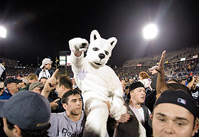Fans carry Jonathan the Husky, while celebrating on the field after the football game against the University of South Florida at Rentschler Field Oct. 27.