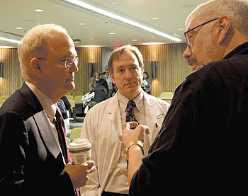 University President Michael J. Hogan, left, speaks with Donald Peterson, director of the biodynamics laboratory, center, and Donald Kreutzer, professor of molecular biology, after a ‘town meeting’ at the Health Center Feb. 15.