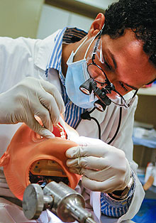 Dental student Gary Warner practices on a model at the Health Center.