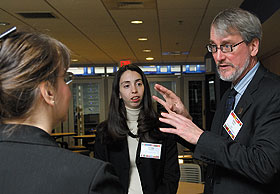 Christopher Earley, dean of business, speaks with Kathleen Bishop, left, and Stacey Witazek, both of UnitedHealth Group, after a breakfast meeting for Hartford area financial leaders at the Graduate Business Learning Center.