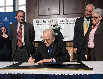University President Michael J. Hogan signs the Presidents’ Climate Commitment March 25, pledging the University to achieve carbon neutrality by 2050.