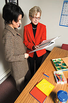 Katherine Gavin, right, associate professor, with Tutita Casa, an assistant professor, look over course-related materials for a math curriculum initiative known as Project M2.