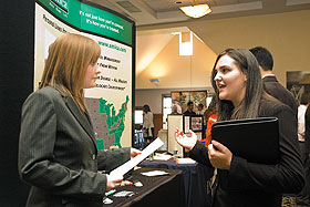 Angela Green, left, an Amica representative, talks to Nicole Newman, a senior majoring in finance, at the Just In Time Fair in Rome Ballroom.