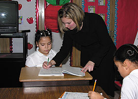 Brittany Richard, a 2006 teacher education graduate, is a special education inclusion teacher for Grades 3 and 4 at Batchelder Elementary School in Hartford. Here she is coaching Reyna Sanabria, while Samantha Ramos works on a paper.