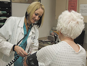 Lori Gordon, a certified medical assistant, takes a patient’s blood pressure at the UConn Health Center’s Carole and Ray Neag Comprehensive Cancer Center.