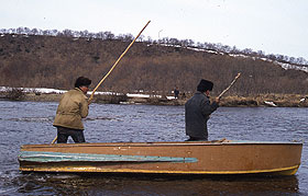 Itelmen men pole a boat upriver.