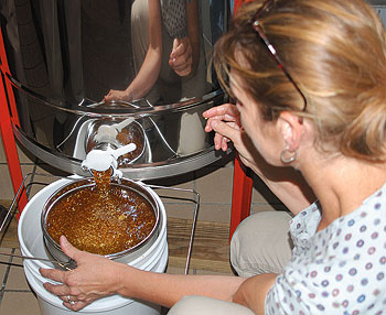 Production chef Amy Gronus, one of UConn’s two beekeepers, collects honey from an extractor. The honey, part of the first crop produced in the University’s own hives, will be used in marinades and sauces prepared in the dining halls.