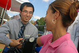 Hee Seop Shin, a second-year medical student, takes a blood pressure reading at C-Town Supermarket in Hartford, part of a day dedicated to community service during National Primary Care Week.