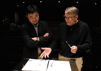 Yuhang Rong, left, associate dean of education, discusses a musical score written by his relative Lu Wei, with Jeffrey Renshaw, professor of music. Renshaw is conductor of the University Symphony Orchestra, which will premiere the work Oct. 10.