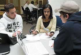 Milanthi Sarukkali, a second-year graduate student in actuarial science, tutors freshmen Brian Libes, left, an exploratory major, and Mike Battipaglia, a business major, in the Q Center.