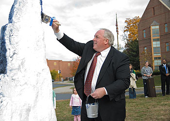 John Driscoll, president of the Alumni Association, participates in a celebration of painting the Rock, a tradition among UConn students. Until recently, the Rock had been in storage because of construction. It is now located at the corner of Hillside Road and Alumni Drive.