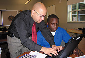 Jason Irizarry, left, an assistant professor of curriculum and instruction, works with Shane Mathis as part of Project FUERTE. 