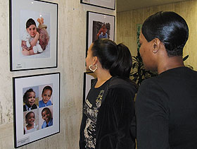 Health Center employees Erika Grant, left, and Tonja Cameron view photos in an exhibit to raise awareness about adoption.