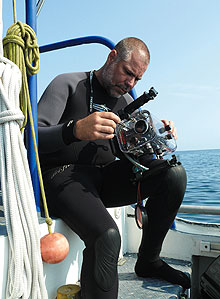 Diving safety officer Jeffrey Godfrey prepares an underwater camera for a dive.