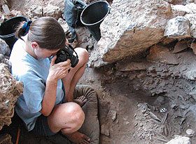 Natalie Munro, associate professor of anthropology, photographing a grave thought to be that of a shaman at the archaeological site of Hilazon Tachtit Cave in northern Israel.