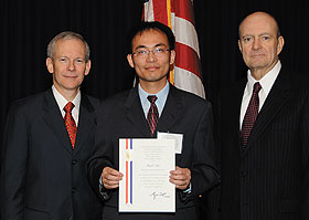 Presidential award-winner Shengli Zhou, center, assistant professor of electrical and computer engineering, with William Rees Jr., left, deputy undersecretary of defense for laboratories and basic sciences, and John Marburger III, science advisor to the President and director of the Office of Science and Technology Policy. 
