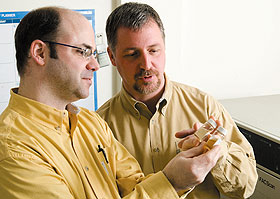 Christopher Perkins, left, lab director at the Center for Environmental Sciences and Engineering, and Sylvain Deguise, associate professor of pathobiology, examine vials of nanosilver particles.