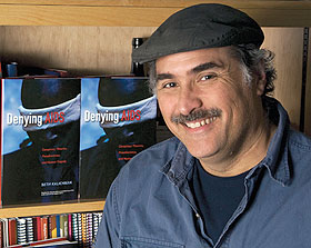 Seth Kalichman, professor of social psychology, with copies of his new book, Denying AIDS.